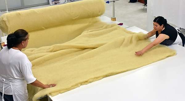 Mise en place de la deuxième couche de nappe de laine aérée pour faire une couette Hajla 400g/m<sup>2</sup>.