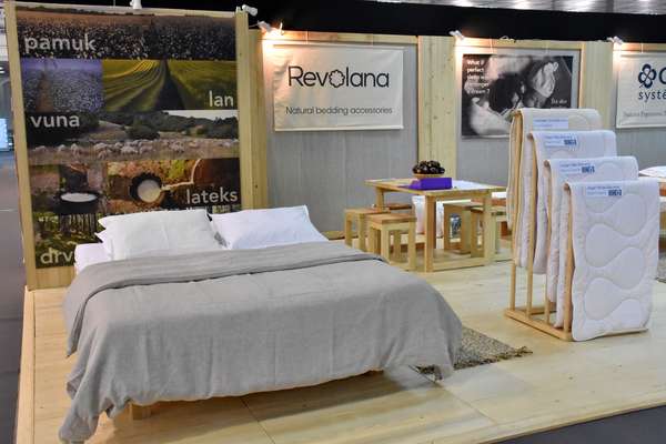The bed presenting Revolana products and the furnitures on the stand.