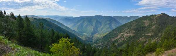 Panorama na kanjonu Uvac. Neasfaltirani put koji silazi prema manastiru Uvac se vidi na desnoj strani slike, a manastir se može videti u centru druge slike.